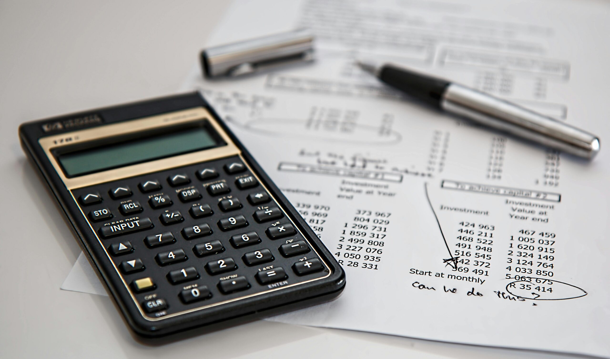 A calculator and tax documents on a desk.